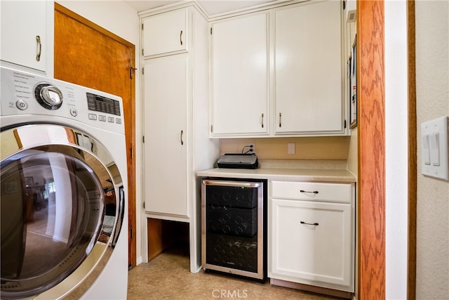 clothes washing area with stacked washer and dryer, beverage cooler, and cabinets