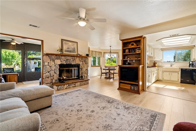 living room with ceiling fan, light wood-type flooring, and a healthy amount of sunlight