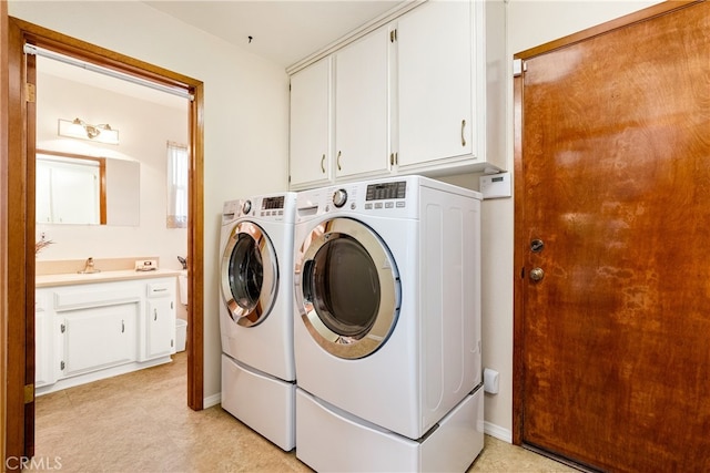 clothes washing area with cabinets and washing machine and dryer