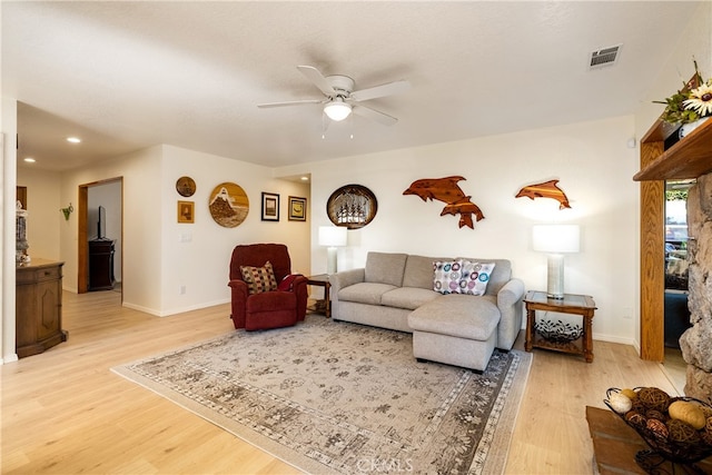 living room with light hardwood / wood-style floors and ceiling fan