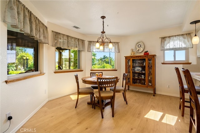 dining room with a notable chandelier and light hardwood / wood-style flooring