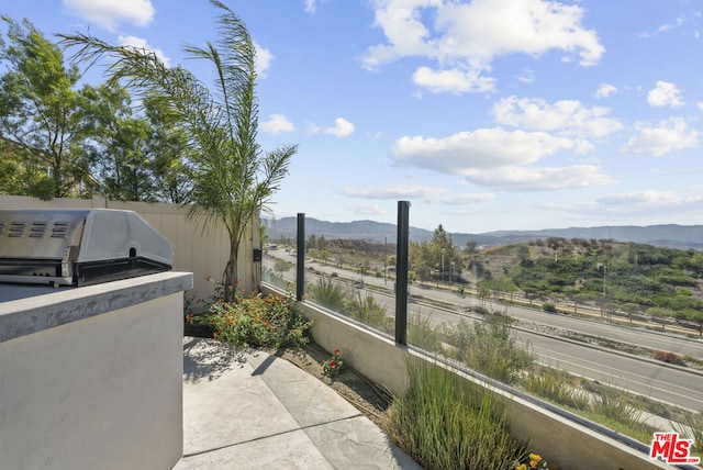 view of patio / terrace with a mountain view and a grill