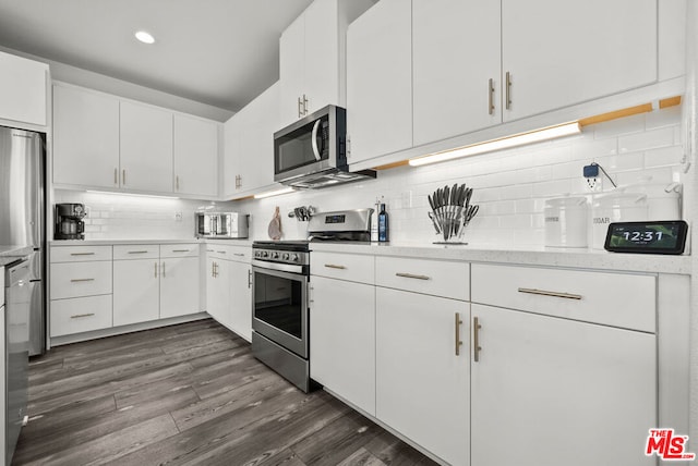 kitchen with decorative backsplash, dark wood-type flooring, stainless steel appliances, and white cabinets