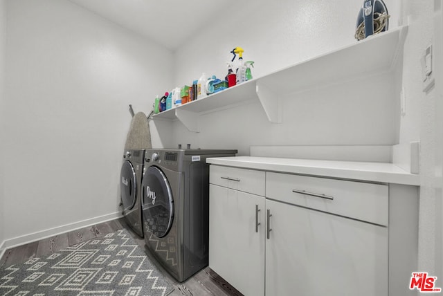 laundry area with cabinets, washer and clothes dryer, and dark hardwood / wood-style flooring