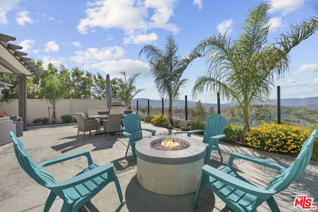 view of patio with a fire pit and a mountain view