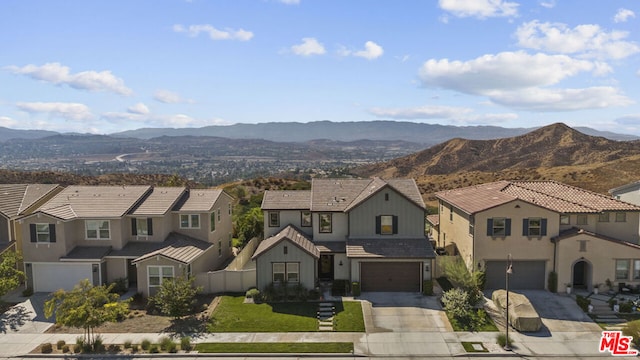 view of front facade with a garage, a front lawn, and a mountain view