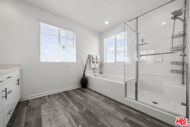 bathroom featuring vanity, wood-type flooring, and shower with separate bathtub