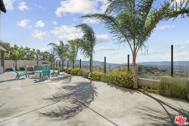 view of patio / terrace featuring a mountain view and a fire pit