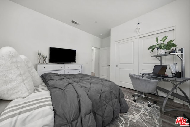 bedroom featuring hardwood / wood-style flooring, a closet, and vaulted ceiling