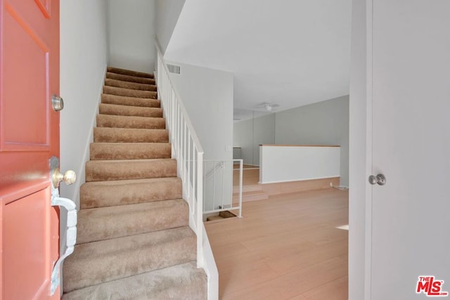 staircase with hardwood / wood-style flooring