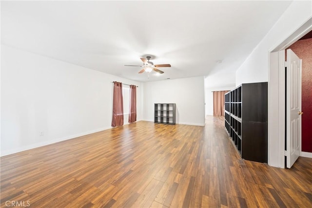 unfurnished living room with ceiling fan and dark hardwood / wood-style flooring