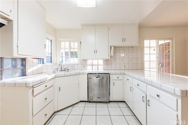 kitchen featuring tile countertops, white cabinetry, dishwasher, and sink