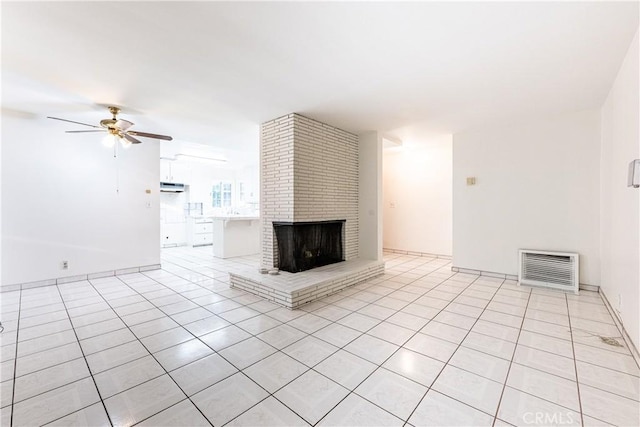 unfurnished living room featuring ceiling fan, light tile patterned flooring, and a brick fireplace