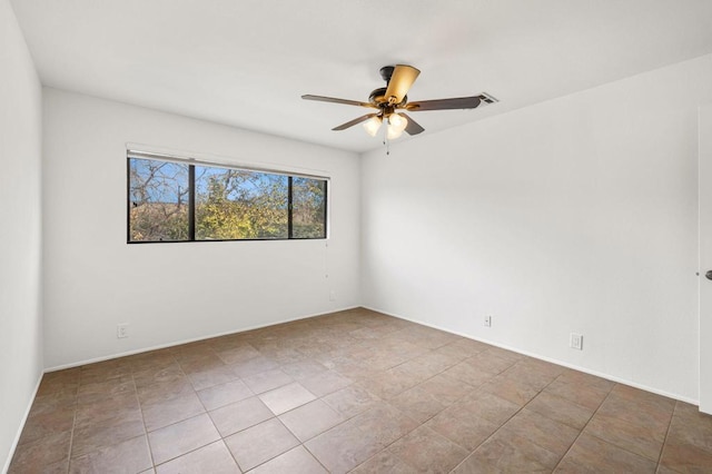 spare room featuring tile patterned flooring and ceiling fan