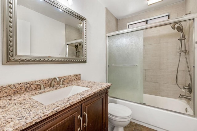 full bathroom featuring tile patterned floors, toilet, vanity, and combined bath / shower with glass door