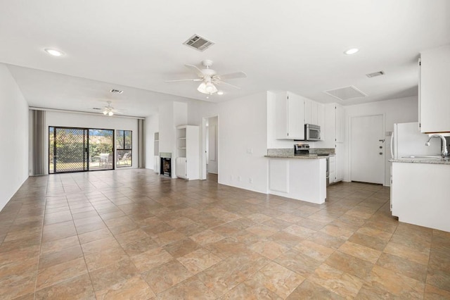 unfurnished living room with ceiling fan and sink