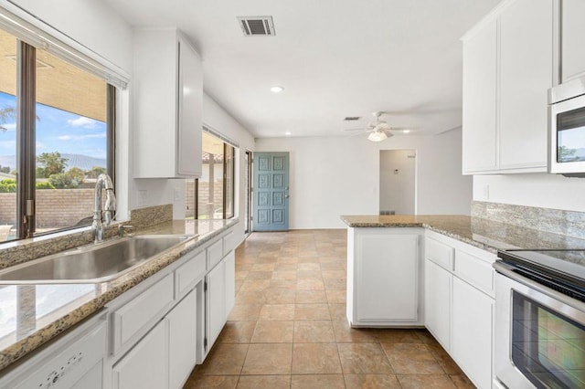 kitchen featuring kitchen peninsula, stainless steel appliances, white cabinetry, and sink