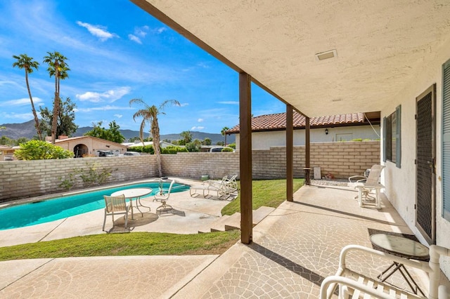 view of patio with a mountain view and a fenced in pool