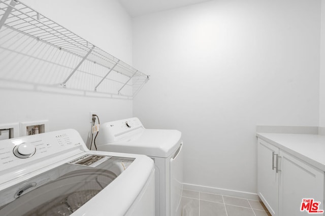 laundry area with washer and dryer, cabinets, and light tile patterned flooring