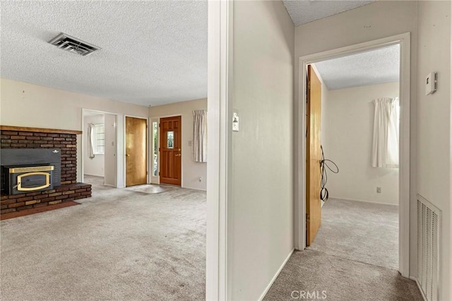 hall with light carpet and a textured ceiling