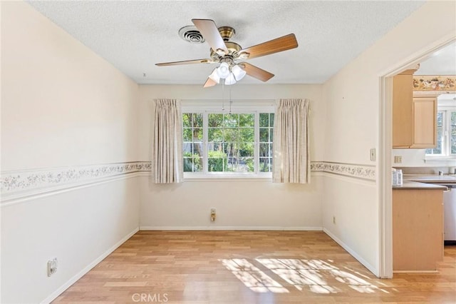 unfurnished room featuring ceiling fan, a textured ceiling, and light hardwood / wood-style flooring