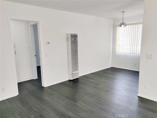 empty room with dark hardwood / wood-style floors and a textured ceiling