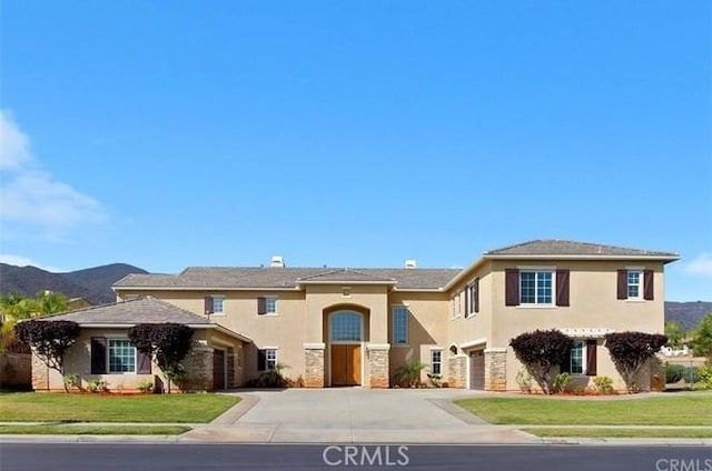 view of front of property featuring a mountain view, a garage, and a front yard