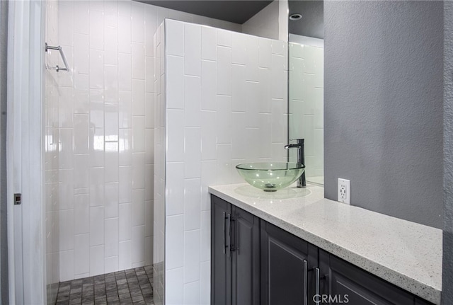 bathroom featuring vanity and tiled shower