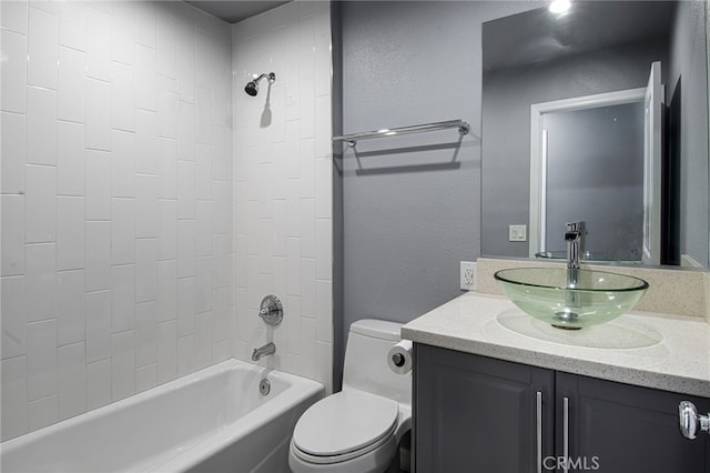 full bathroom featuring vanity, tiled shower / bath combo, and toilet