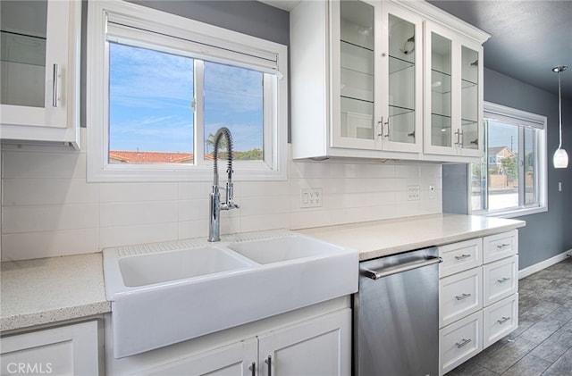 kitchen with white cabinets, plenty of natural light, sink, and hanging light fixtures