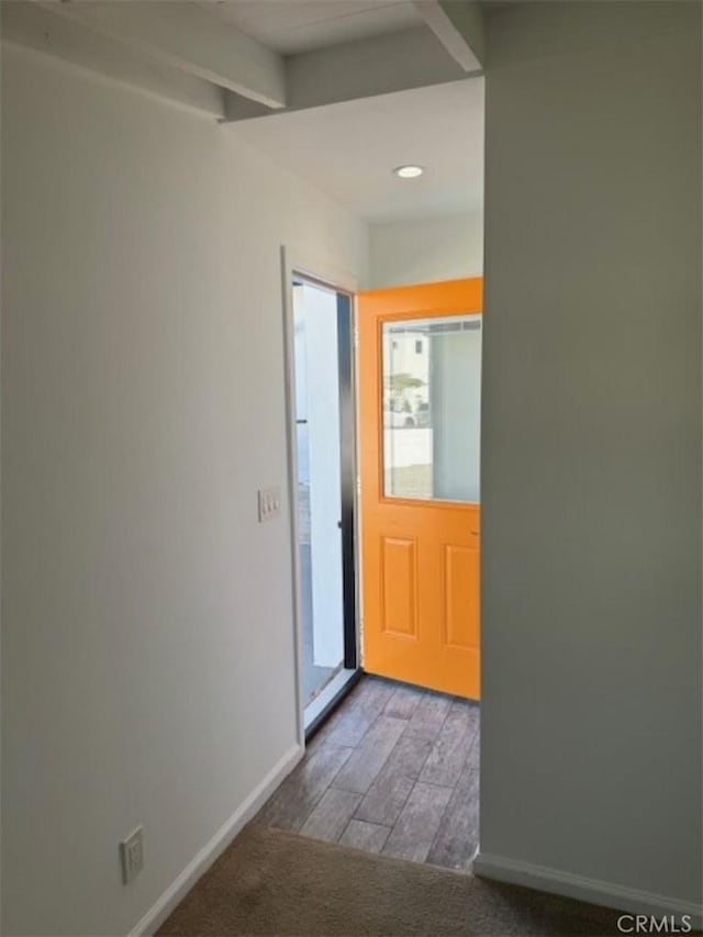 doorway to outside featuring beamed ceiling and hardwood / wood-style flooring