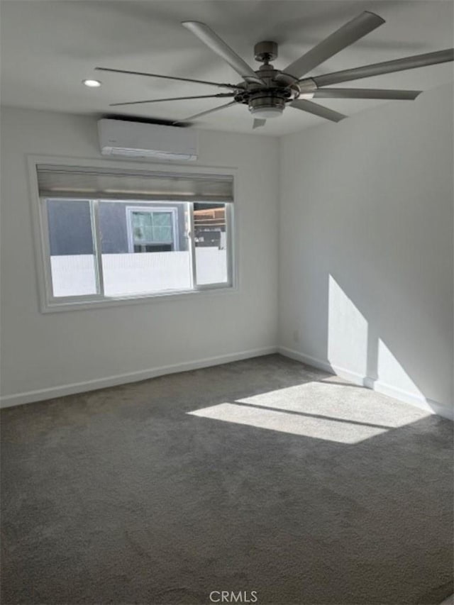 spare room with dark carpet, a wall mounted AC, and ceiling fan