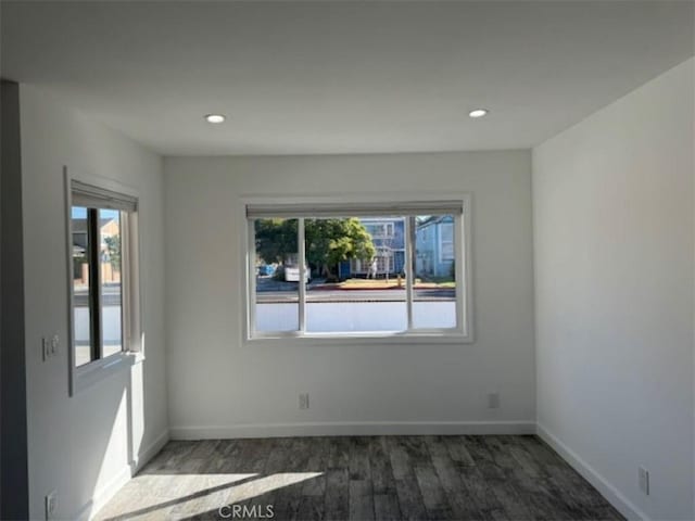 empty room with plenty of natural light and dark hardwood / wood-style floors