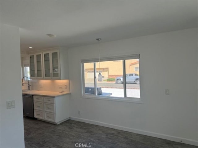 kitchen with white cabinets, dishwasher, decorative backsplash, and sink