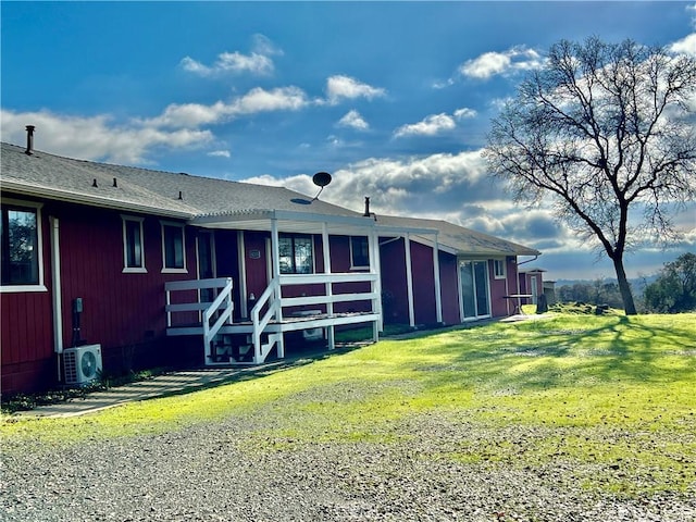 back of house with ac unit and a yard