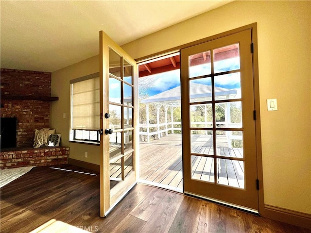 doorway to outside with french doors, a fireplace, and wood-type flooring