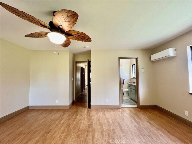 spare room featuring light hardwood / wood-style floors, ceiling fan, and a wall mounted AC