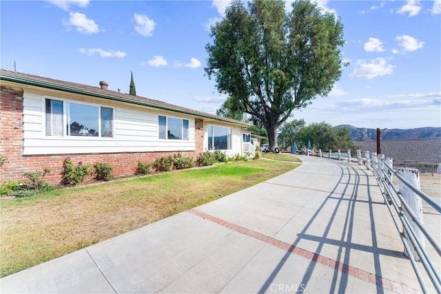 ranch-style home with a front lawn and a mountain view