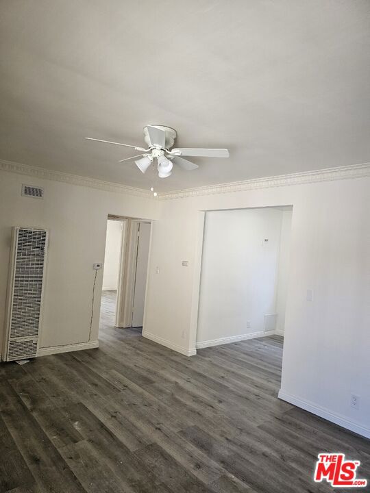 spare room with ceiling fan, dark hardwood / wood-style floors, and ornamental molding