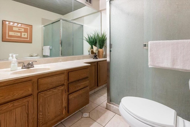 bathroom featuring tile patterned flooring, vanity, toilet, and a shower with shower door