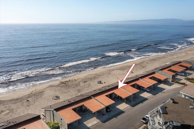 drone / aerial view with a water view and a beach view