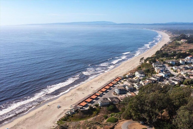 birds eye view of property with a water view and a beach view