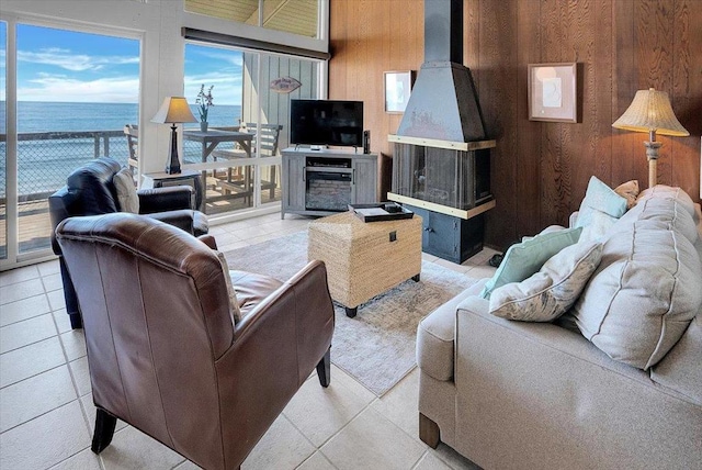 tiled living room featuring a water view and wooden walls