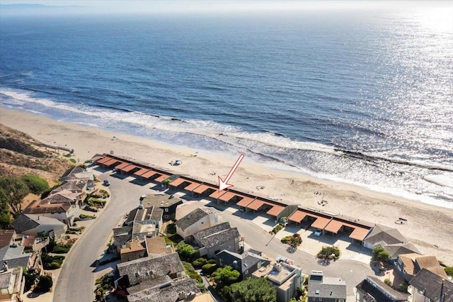 birds eye view of property with a water view and a beach view