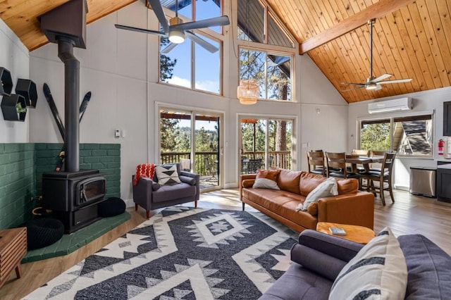 living room with beam ceiling, a wood stove, ceiling fan, high vaulted ceiling, and plenty of natural light