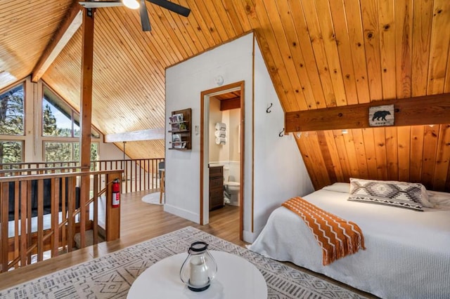 bedroom featuring wooden ceiling, lofted ceiling with beams, wooden walls, ensuite bath, and light hardwood / wood-style floors