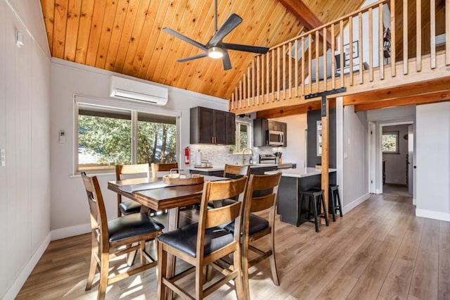 dining area featuring light hardwood / wood-style floors, high vaulted ceiling, a wall mounted AC, and a healthy amount of sunlight