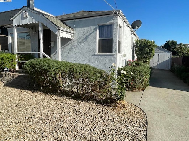 view of side of home featuring a garage and an outbuilding