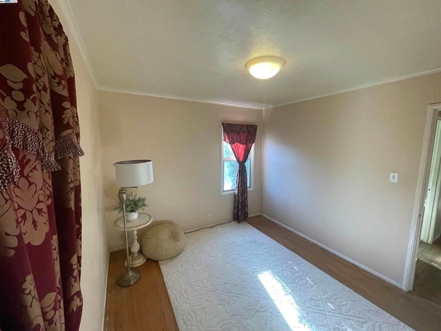 spare room featuring hardwood / wood-style flooring and ornamental molding