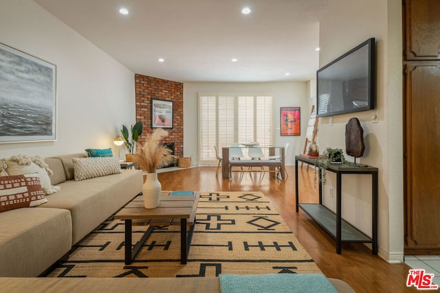 living room with light hardwood / wood-style flooring and a brick fireplace